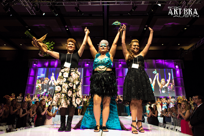 3 ladies with raised hands on fashion runway